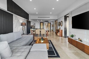 A modern living room with a sofa, coffee table, and a TV. - Deck12 Casino and Resort by Monyxbnb (Puerto Vallarta)