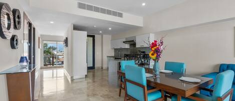 A modern dining area with a table, chairs, and a vase of flowers.
