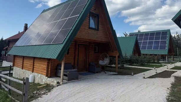 A wooden cabin with a sloped roof and solar panels. - Old Story Chalets (Žabljak)