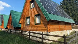 A wooden cabin with a sloped roof and solar panels. - Old Story Chalets (Žabljak)