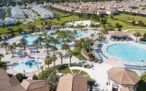 Resort com várias piscinas, palmeiras e áreas de descanso.