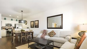 Een moderne woonkamer met een bank, salontafel en een eethoek.