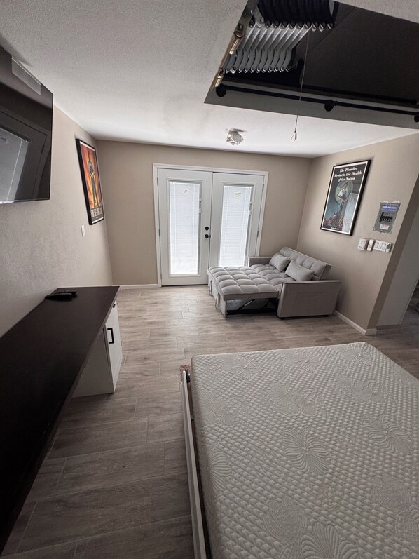 Une chambre avec un lit, un canapé-lit, un bureau et une fenêtre.