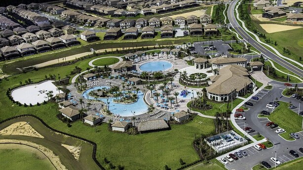 An aerial view of a resort with a central pool, multiple buildings, and a parking area. - Themed Home w/ Private Pool (Davenport)