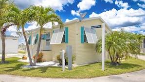 A single-story building with a beige exterior and green shutters, labeled "Indian Parkway North." - Ocean Breeze 2BR/2BA Beach Getaway (Fort Myers Beach)