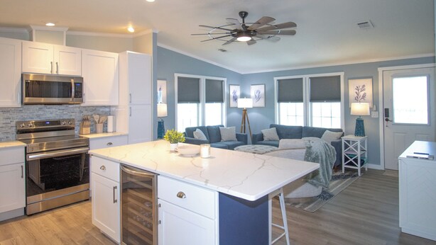 A modern kitchen with white cabinets, a stainless steel oven, and a marble island. - Ocean Breeze 2BR/2BA Beach Getaway (Fort Myers Beach)