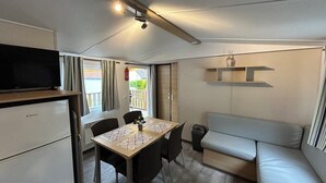 Un espace de vie compact comprenant un coin cuisine, un coin repas et un canapé.