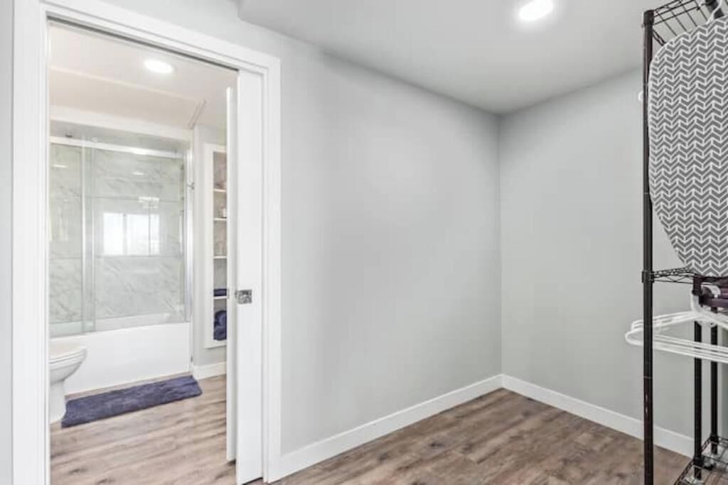 A bathroom with a shower, toilet, and a towel rack.