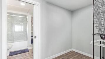 A bathroom with a shower, toilet, and a towel rack.