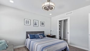 A bedroom with a bed, bedside table, and a wardrobe. - Chic & Stylish Midtown PHX Condo Retreat - Stunning Views & Light Rail Access (Phoenix)