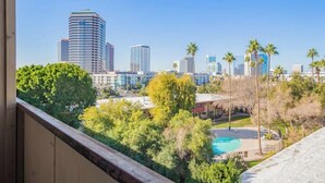 A city skyline with modern high-rise buildings, a swimming pool, and surrounding greenery. - Chic & Stylish Midtown PHX Condo Retreat - Stunning Views & Light Rail Access (Phoenix)