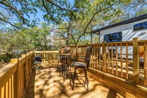 A wooden deck with outdoor furniture, a grill, and a small building with windows. - Private Lakeside RV Escape with Hot Tub, Multi-Level Deck, & Easy Water Access (Corsicana)