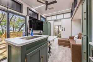 A modern kitchen with a large island, a built-in oven, and a ceiling fan.