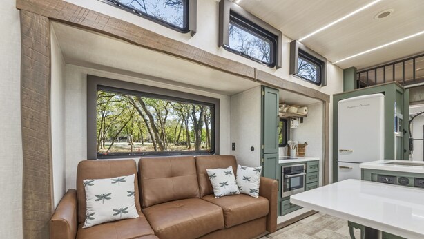 A modern kitchen with a built-in oven, a refrigerator, and a window overlooking a garden. - Private Lakeside RV Escape with Hot Tub, Multi-Level Deck, & Easy Water Access (Corsicana)