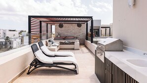 A rooftop terrace with a seating area, a built-in sink, and a view of the city. - Palmares (Playa del Carmen)