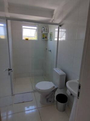 Chuveiro, toalhas de banho, papel higiênico