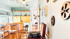 Une cuisine chaleureuse, avec des meubles en bois, un tourne-disque et des œuvres d’art décoratives accrochées aux murs.