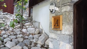 Pareda de pedra com porta de madeira e uma placa com a letra 'A'.