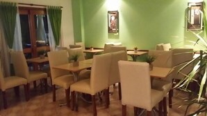 A dining area with tables and chairs, green walls, and framed pictures on the walls. - Totem de Mar (Valeria del Mar)