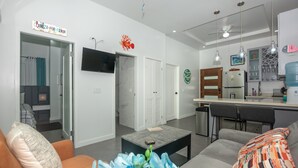 Een moderne woonkamer met een bank, salontafel en een televisie aan de muur.