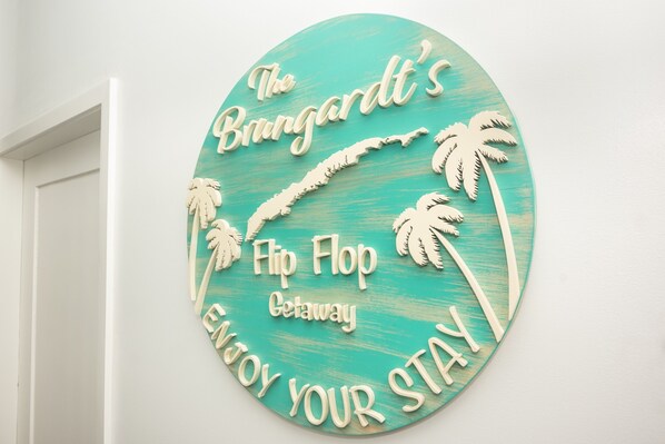 A circular sign with text and palm tree cutouts.