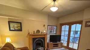 A living room with two brown sofas, a fireplace, a television, and a large window with a view. - ☘️Spacious Family Home in Belfast (Belfast)