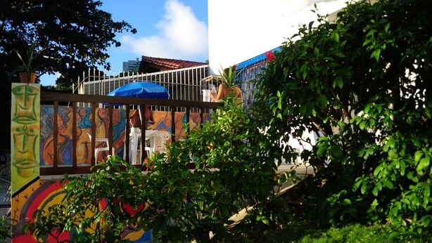A colorful mural with abstract art and a blue umbrella. - Sopro de Iemanjá Hostal (Salvador)