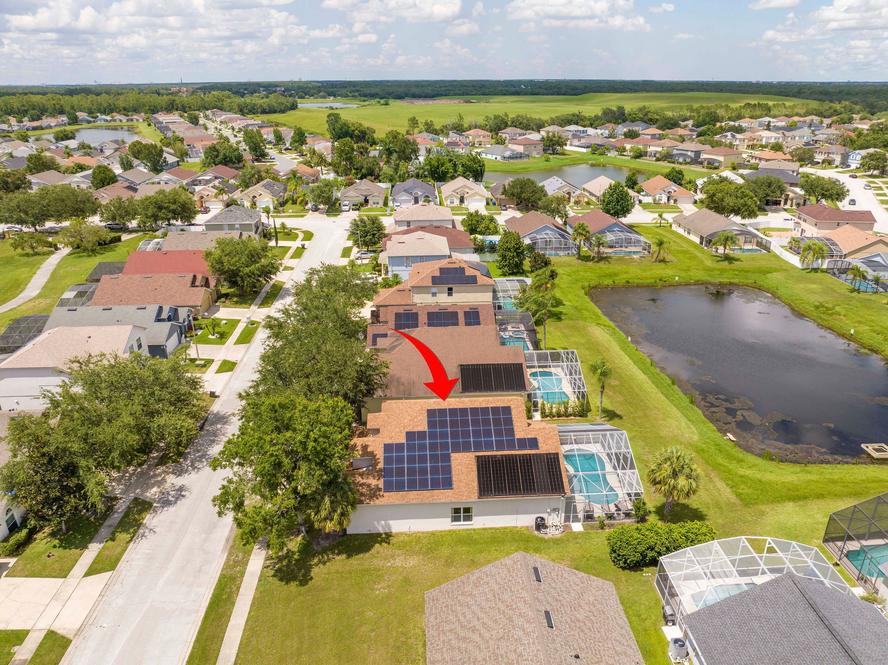 A residential area with houses, a swimming pool, and solar panels on a house.