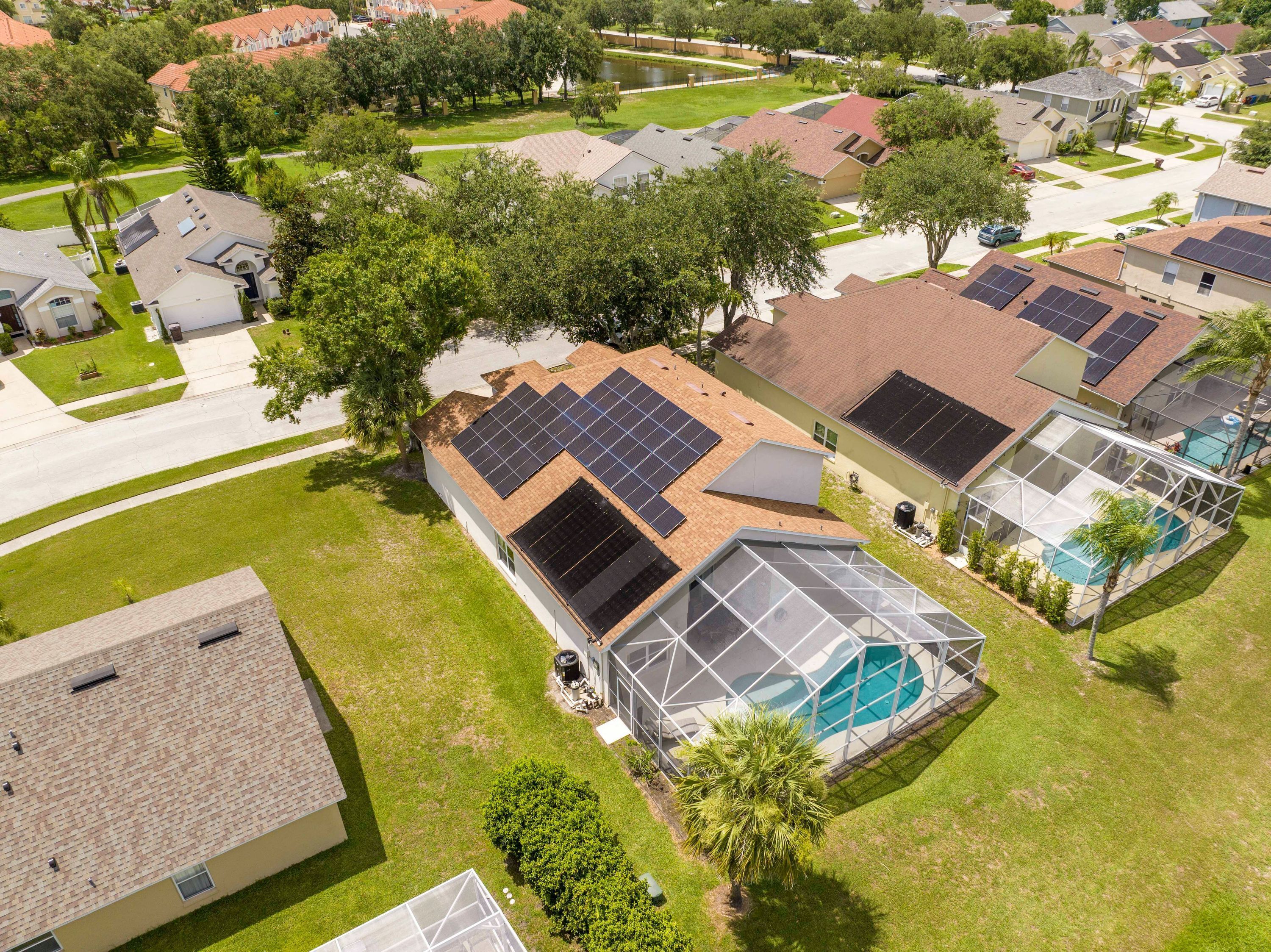 A residential area with houses, solar panels, and a swimming pool.