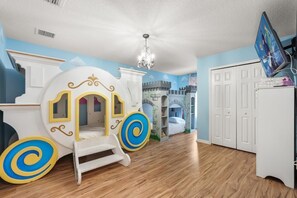 A child's playroom with a castle-themed playhouse, a bed, and a television. - Ultimate Themed Getaway w/ Pool, Hot Tub & Theater! BY DISNEY! (Kissimmee)