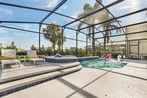 A pool area with lounge chairs and a hot tub, surrounded by palm trees and a clear sky. - Ultimate Themed Getaway w/ Pool, Hot Tub & Theater! BY DISNEY! (Kissimmee)