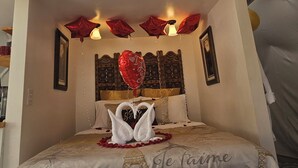 A cozy bedroom with a bunk bed, a decorative Eiffel Tower on the bedspread, and a skylight above. - The Glamp Inn (Lincolnton)