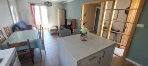 A modern living room with a dining area, a TV, and a wooden partition. - Villa near the beach (La Garde)