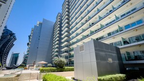A modern high-rise building with multiple balconies and a clear sky. - Stylish Studio at DAMAC Majestine (Dubai)
