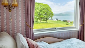 A bedroom with a large window, a bed, and a wall-mounted lamp. - Awesome home in Fitjar with WiFi (Fitjar)