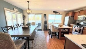 Une cuisine spacieuse avec des meubles en bois, un grand îlot central et une vue sur l’extérieur.