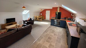 A modern loft apartment with a living room, dining area, and kitchen.