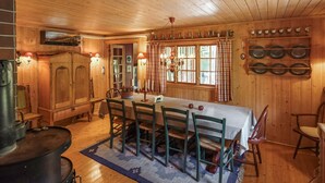 A wooden interior with a dining table, chairs, a chandelier, and a kitchen area with pots and pans. - Awesome home in Uvdal with sauna (Uvdal)
