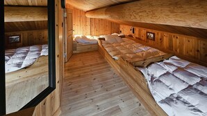 A wooden cabin with two bunk beds, a wooden floor, and a sloped ceiling. - Cozy home in Hemsedal with sauna (Hemsedal)