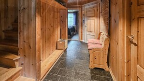A wooden interior with a staircase, a bench, and a door leading to another room. - Cozy home in Hemsedal with sauna (Hemsedal)