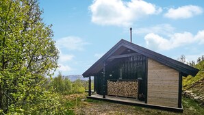 A modern cabin with a sloped roof, a chimney, and a number '18' sign. - Amazing home in Edland with sauna (Edland)