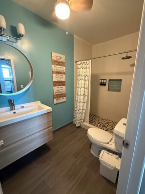 Chuveiro, toalhas de banho, sabonete, papel higiênico