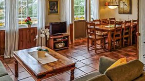 A spacious living area with a wooden coffee table, a television, and a dining table with chairs. - Lovely home in Lindesnes with sauna (Lindesnes)