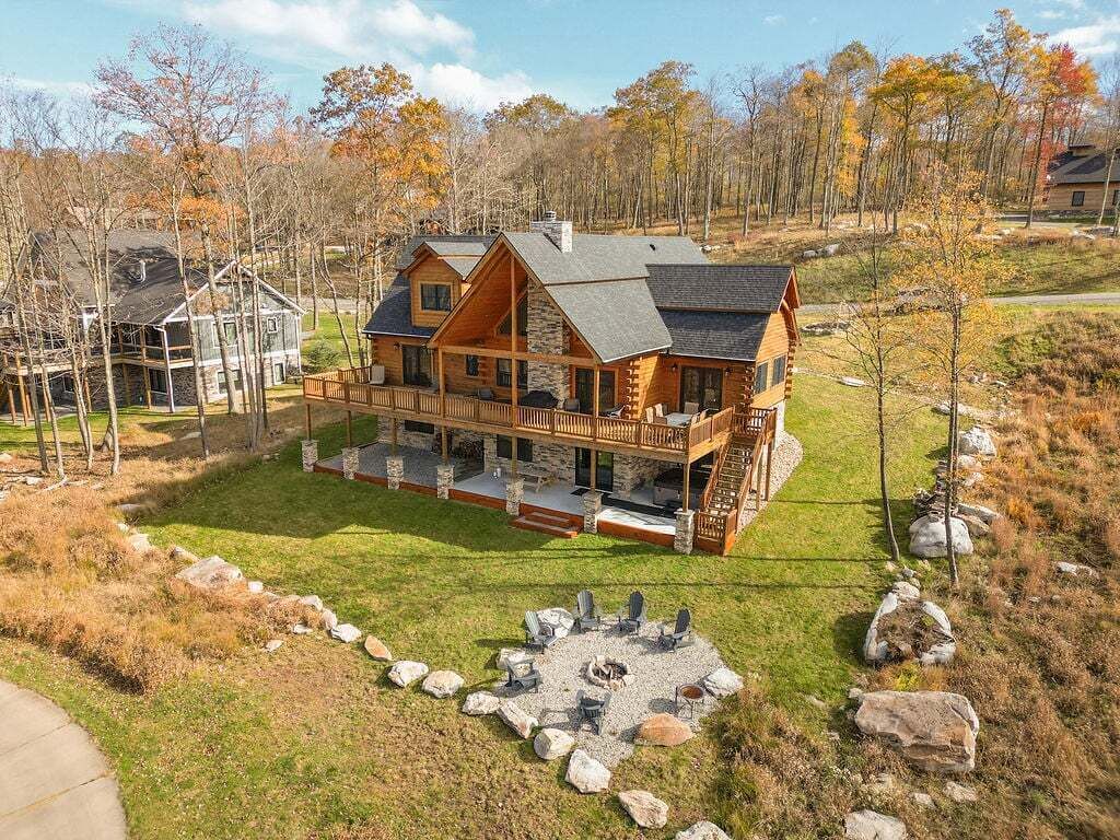 A large log cabin with a deck and outdoor seating area.