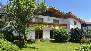A two-story house with a well-maintained garden, a wooden balcony, and a satellite dish. - Panoramablick by Interhome (Reutte)