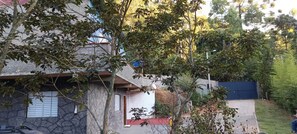 A residential building with a stone facade, a red roof, and a visible garage door. - Refugio Jaguary Country House (Monte Verde)