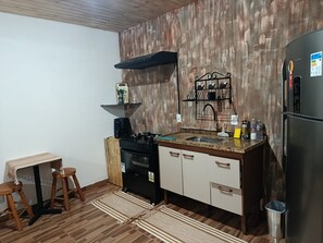 A compact kitchen with a gas stove, a coffee maker, and a sink. - Refugio Jaguary Country House (Monte Verde)
