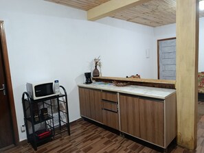 A kitchen with a microwave, coffee maker, and a shelf with jars. - Refugio Jaguary Country House (Monte Verde)