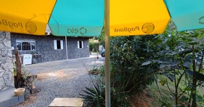 A building with a stone facade, a paved entrance, and a garden area with greenery. - Refugio Jaguary Country House (Monte Verde)