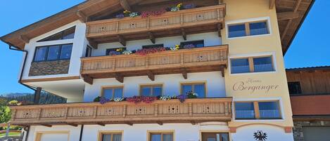 A multi-story hotel with wooden balconies, flower boxes, and a sign indicating it is a B&B.